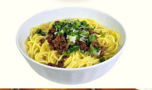 Minced Beef Thukpa on a white plate against a white background.