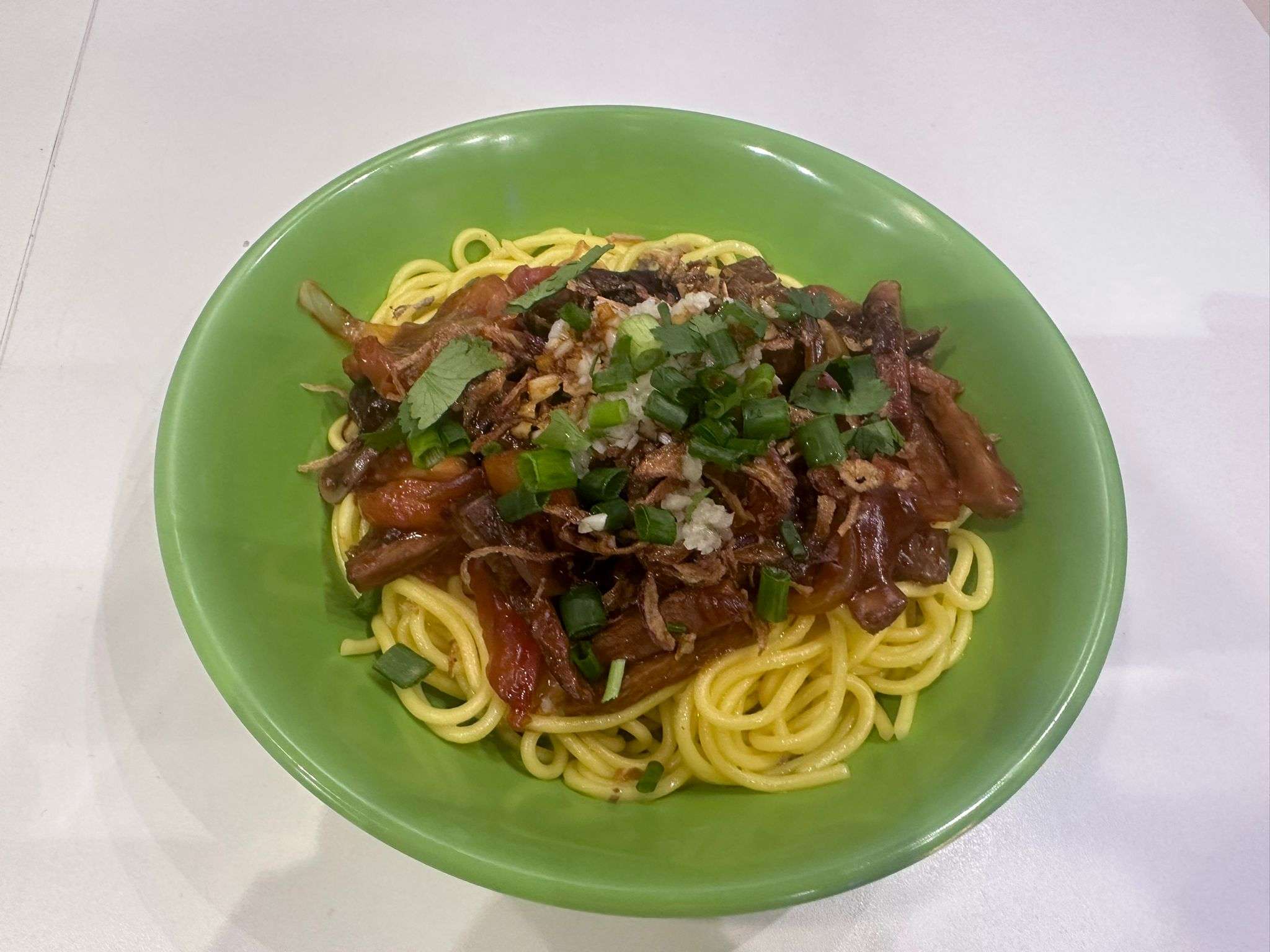 Tibetan Dhankdu (Cold Thukpa) in a green bowl against a white background