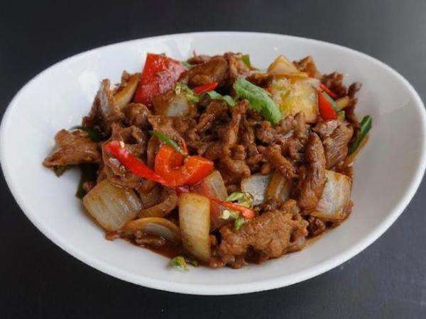 Shabtak Beef on a white plate against a dark background.