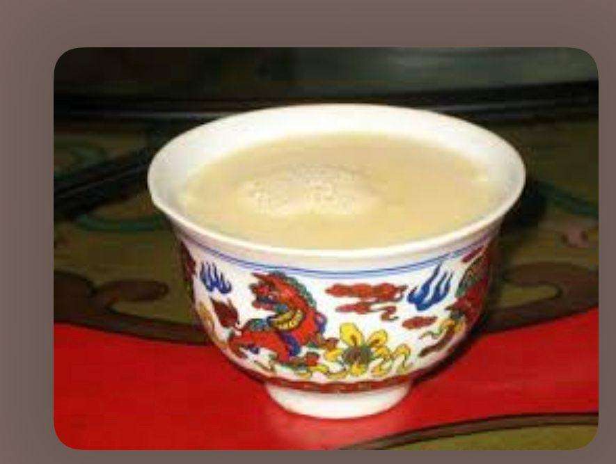 Tibetan Salted Butter Tea in a beautiful artisan cup against a dark background.
